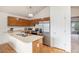 Bright kitchen featuring wood cabinets, stainless steel appliances, and a view into the dining room at 12632 James Ct, Broomfield, CO 80020