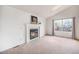 Bright living room featuring a cozy fireplace, neutral walls, and a large window at 12632 James Ct, Broomfield, CO 80020