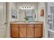 Double sink bathroom vanity featuring wooden cabinetry and generous lighting at 7140 Simms St # 102, Arvada, CO 80004