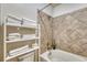 Bright bathroom featuring tile detail, a stacked towel rack, and shower-tub combination at 7140 Simms St # 102, Arvada, CO 80004