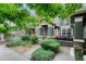Charming townhome entrance with covered porch, stone accents, and well-maintained landscaping at 7140 Simms St # 102, Arvada, CO 80004