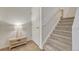 Inviting hallway with carpeted staircase, neutral decor, and functional storage space at 7140 Simms St # 102, Arvada, CO 80004
