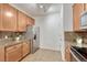 Well-lit kitchen featuring stainless steel refrigerator, stone countertops, and wood cabinets at 7140 Simms St # 102, Arvada, CO 80004