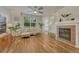 Inviting living room featuring a fireplace, wood floors, and natural light from the large window at 7140 Simms St # 102, Arvada, CO 80004