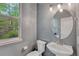 Stylish powder room with elegant fixtures, oval mirror and pleasant natural lighting at 7140 Simms St # 102, Arvada, CO 80004