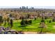 Areal view of suburban neighborhood featuring Denver skyline, tree coverage, and golf course at 5101 Quitman St, Denver, CO 80212