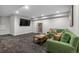 Finished basement featuring a comfortable green sofa, coffee table, and large TV at 5101 Quitman St, Denver, CO 80212