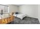 Modern bedroom featuring a simple bed frame, white bedding, and a wooden desk at 5101 Quitman St, Denver, CO 80212