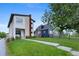 Modern two-story home with manicured lawn, stone accents, and neighboring blue house under a mature tree at 5101 Quitman St, Denver, CO 80212