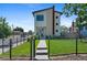 Beautiful modern two-story home featuring a stone chimney, well-manicured lawn, and black metal fencing at 5101 Quitman St, Denver, CO 80212