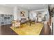 Open concept living room with a yellow rug and seamless flow to the kitchen and dining area at 5101 Quitman St, Denver, CO 80212