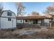 Exterior of home in backyard with shed, patio, mature trees, and full fence at 795 Troy Ct, Aurora, CO 80011