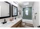 Updated bathroom features a double vanity, black fixtures, skylight, and tiled shower-tub at 795 Troy Ct, Aurora, CO 80011