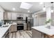 This kitchen features modern appliances, stainless steel refrigerator, quartz countertops and skylight at 795 Troy Ct, Aurora, CO 80011