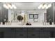 Modern bathroom featuring a double vanity with gold fixtures, sleek mirrors, and a glass-enclosed shower at 3709 Tejon St, Denver, CO 80211