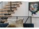 Floating wood staircase with black metal railing, complemented by a colorful piece of modern art on the wall at 3709 Tejon St, Denver, CO 80211
