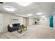 Finished basement with decorative ceiling tiles, plush carpeting, and cozy seating area for relaxing or entertaining at 7413 S Tamarac St, Centennial, CO 80112