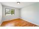 Light bedroom featuring hardwood floors and a large window for natural light and tree views at 7413 S Tamarac St, Centennial, CO 80112