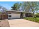 Brick home boasts a spacious driveway leading to an attached garage, complemented by a beautifully maintained front lawn at 7413 S Tamarac St, Centennial, CO 80112
