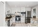 Modern kitchen with stainless steel appliances, white cabinets, and marble-look countertops create a bright and stylish space at 7413 S Tamarac St, Centennial, CO 80112