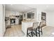 Bright kitchen features stainless steel appliances, tile floors, white cabinets, and breakfast bar with seating at 7413 S Tamarac St, Centennial, CO 80112