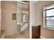 Modern bathroom showcasing a sleek glass-enclosed shower, decorative stone accent, and a window with natural light at 3122 Perry St, Denver, CO 80212