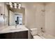 Well-lit bathroom featuring a modern sink and vanity, toilet, and a shower-tub combination with contemporary fixtures at 3122 Perry St, Denver, CO 80212