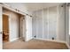 Charming bedroom with a sliding barn door, accent wall with tree pattern, creating a whimsical and inviting space at 3122 Perry St, Denver, CO 80212