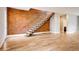 Open living room showcasing a modern staircase, hardwood floors, and exposed brick wall at 3122 Perry St, Denver, CO 80212