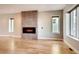 Open living room with a modern fireplace and light hardwood floors, enhanced by natural light at 3122 Perry St, Denver, CO 80212