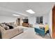 Finished basement with a large sectional couch, TV, a bookcase, and a window for natural lighting at 3269 W 101St Cir, Westminster, CO 80031