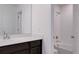 Bathroom featuring modern sink and vanity with bright shower and bath in background, creating a functional and clean space at 9250 Rifle St, Commerce City, CO 80022