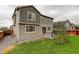 Back exterior of a two story home with a small deck, fenced yard and well maintained lawn at 9250 Rifle St, Commerce City, CO 80022