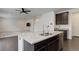 Open-concept kitchen with a central island, stainless steel appliances, and views of the living room at 9250 Rifle St, Commerce City, CO 80022