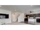 Open living space combining a kitchen, living room, and staircase for contemporary living at 9250 Rifle St, Commerce City, CO 80022