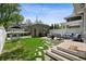 Spacious backyard with a stone patio, deck with outdoor seating, grassy area, and charming landscaping for outdoor enjoyment at 758 N Franklin St, Denver, CO 80218