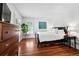 Bedroom with hardwood floors, a black bed frame, white walls, and a large window with shutters at 758 N Franklin St, Denver, CO 80218