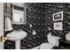 Stylish powder room with black and white floral wallpaper, pedestal sink, and elegant silver mirror at 758 N Franklin St, Denver, CO 80218