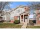 Traditional home with brick accents, white siding, well-manicured lawn, and inviting front porch at 10700 Kimblewyck Cir # 225, Northglenn, CO 80233