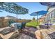 Backyard offers patio seating, a lawn, fenced yard, and shade provided by colorful umbrellas at 6924 E 118Th Pl, Thornton, CO 80233