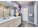 Well-lit bathroom featuring double sinks, vanity and a glass enclosed shower at 6924 E 118Th Pl, Thornton, CO 80233