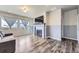 Cozy living room features a fireplace, large windows, wood floors and a comfortable gray couch at 6924 E 118Th Pl, Thornton, CO 80233