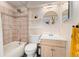 Bathroom featuring tiled shower and tub, single sink vanity, and round mirror at 7211 Wiltshire Ct, Highlands Ranch, CO 80130