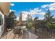 Upper deck has grill, table, and chairs, with a view of backyard and surrounding trees at 7211 Wiltshire Ct, Highlands Ranch, CO 80130