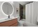 Updated bathroom featuring a modern vanity, updated lighting, and tiled shower with curtain at 3025 Ivanhoe St, Denver, CO 80207