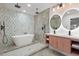 Modern bathroom featuring dual shower heads, soaking tub, dual sinks, and unique tile work at 3025 Ivanhoe St, Denver, CO 80207