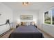 Bright bedroom featuring a large window, modern lighting fixture, and stylish decor with a gray bedspread at 3025 Ivanhoe St, Denver, CO 80207
