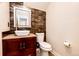 A half bath with a modern sink, dark wood accents, and a decorative mirror at 3841 Colorful Ln, Castle Rock, CO 80109