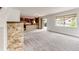 Spacious living room featuring stone accents, carpeted flooring, and a sliding door to the backyard at 3841 Colorful Ln, Castle Rock, CO 80109