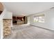 Open-concept living room flowing into the kitchen, showcasing a cozy stone fireplace at 3841 Colorful Ln, Castle Rock, CO 80109